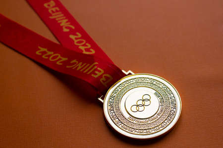 January 6, 2021, Beijing China. Gold medal of the XXIV Olympic Winter Games on an orange background.のeditorial素材