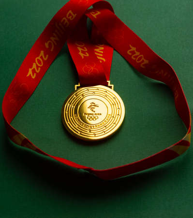 January 6, 2021, Beijing China. Gold medal of the XXIV Olympic Winter Games on a green background.のeditorial素材