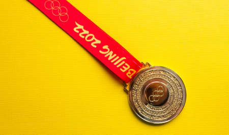 January 6, 2021, Beijing China. Gold medal of the XXIV Olympic Winter Games on a yellow background.のeditorial素材