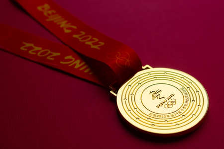 January 6, 2021, Beijing China. Gold medal of the XXIV Olympic Winter Games on a red background.のeditorial素材