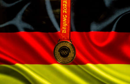 January 5, 2021, Beijing China. Gold medal of the XXIV Olympic Winter Games against the background of the flag of Germany.のeditorial素材