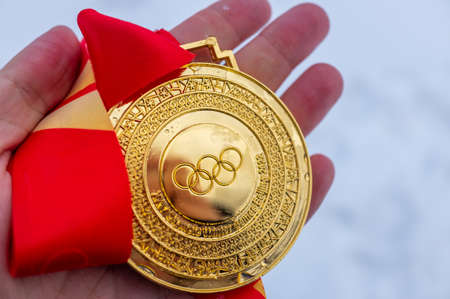 January 4, 2022, Beijing, China. Gold medal of the XXIV Olympic Winter Games in the palm of your hand.のeditorial素材