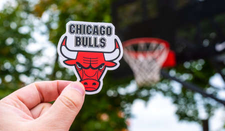 September 15, 2021, Chicago, USA, A man holds the emblem of the Chicago Bulls basketball club in his...