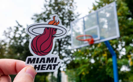 September 15, 2021, Miami, USA, A man holds the emblem of the Miami Heat basketball club in his hand on the sports ground.のeditorial素材