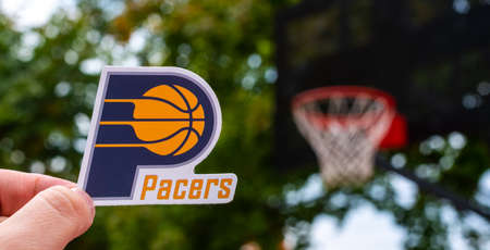September 15, 2021, Indianapolis, USA, A man holds the emblem of the Indiana Pacers basketball club in his hand on the sports field.のeditorial素材