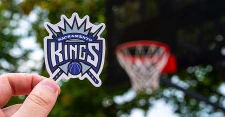 September 15, 2021, Sacramento, USA, A man holds the emblem of the Sacramento Kings basketball club in his hand on the sports field.のeditorial素材