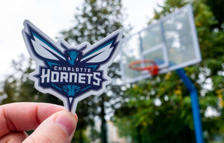 September 15, 2021, Charlotte, USA, A man holds the logo of the Charlotte Hornets basketball club in...