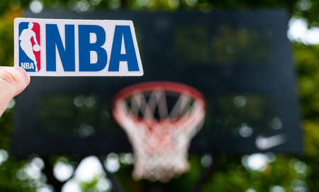 September 15, 2021, Springfield, USA, A man holds the emblem of the National Basketball Association in his hand on the sports field.のeditorial素材