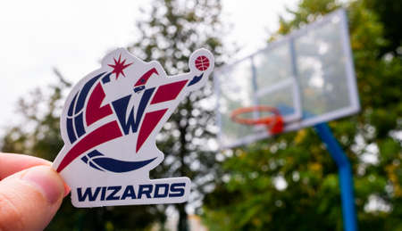 September 15, 2021, Washington, USA, A man holds the emblem of the Washington Wizards basketball club in his hand on the sports field.のeditorial素材