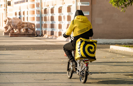 October 6, 2021, Moscow, Russia. An employee of the Yandex Food delivery service on a bicycle on one of the streets in the Russian capital.のeditorial素材
