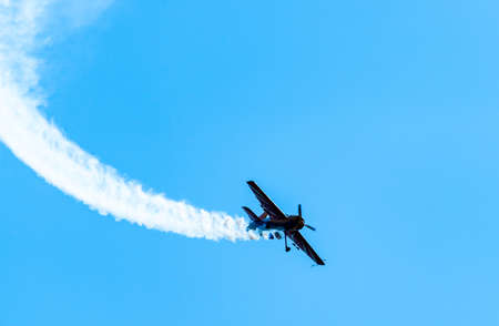 Silhouettes of training aircraft performing aerobatics on a clear sunny day.の写真素材