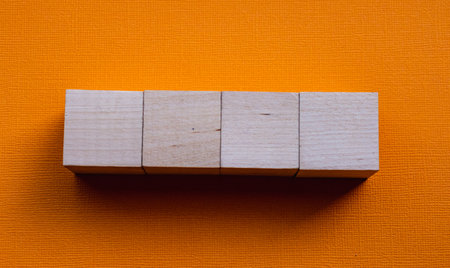 Four wooden cubes on orange background, mockup