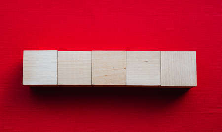 Five wooden cubes on a red background, mocap