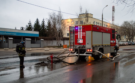 December 13, 2019, Moscow, Russia. A firefighter watches as a fire truck draws water from a fire...