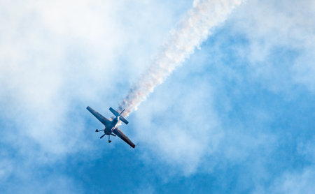 Silhouettes of training aircraft performing aerobatics on a clear sunny day.