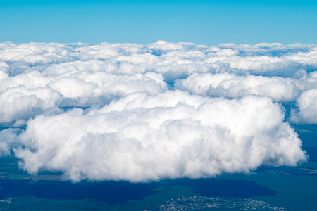 View of the white clouds in the blue sky from the window of the aircraft.