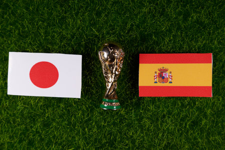 November 20, 2022, Doha, Qatar. Flags of Japan and Spain and the FIFA World Cup trophy on the green lawn of the stadium.のeditorial素材
