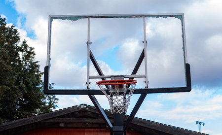 Broken glass backboard and broken hoop on the basketball court