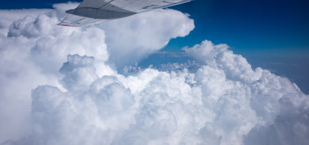 White clouds in the blue sky under the wing of the planeの写真素材