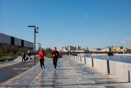 April 29, 2022. Moscow, Russia. Young people on a jog on the embankment in Muzeon Park.のeditorial素材