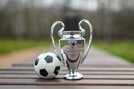 November 8, 2023, London, United Kingdom. UEFA Champions League Cup on a wooden bench in the park.のeditorial素材