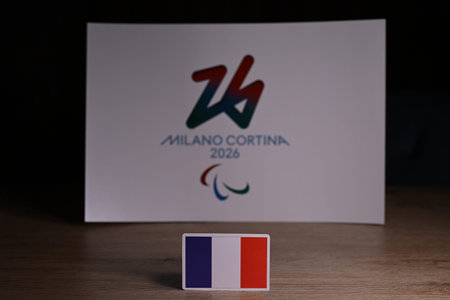 February 9, 2026. Milan, Italy. The flag of France on the background of the logo of the XIV...