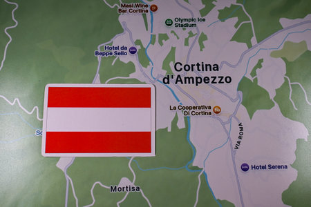 February 9, 2026, Milan, Italy. The flag of Austria on the background of the Cortina d'Ampezzo map of one of the host cities of the XXV Winter Olympic Games logo and commonly known as Milano Cortina 2026のeditorial素材