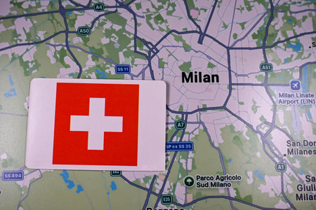 February 9, 2026, Milan, Italy. The flag of Switzerland on the background of a map of Milan, one of the host cities of the XXV Winter Olympic Games logo and commonly known as Milano Cortina 2026のeditorial素材