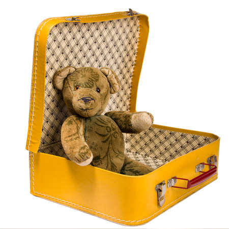 Antique Teddy bear sitting in a yellow suitcase wants to travelの写真素材