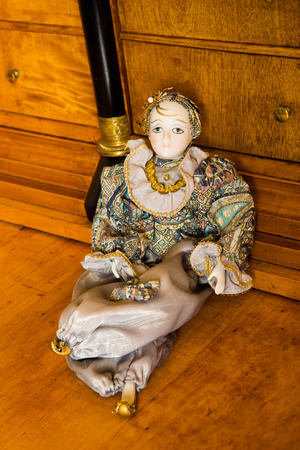 Harlequin doll on an antique cherry wood desk with porcelain faceの写真素材