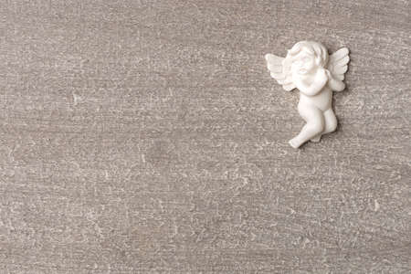 Praying angel on gray wood backgroundの写真素材