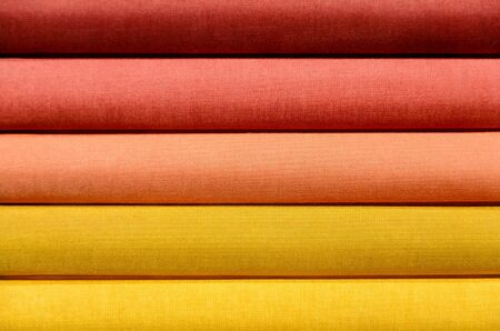 Stack of Book spines covered with linen for background purpose, red, orange, yellow