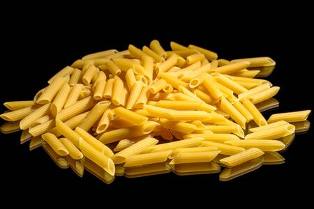 Heap of macaroni noodles reflecting on black background.の写真素材