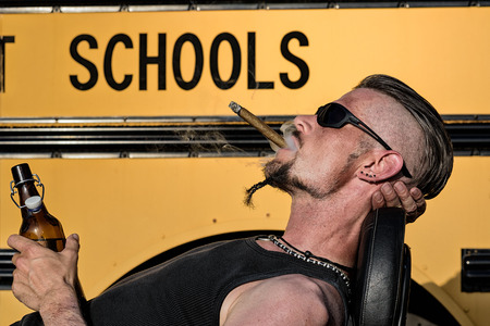 Bad Boys do not like school: Tough guy with sparrow beard, undercut and blue jeans leaning against...