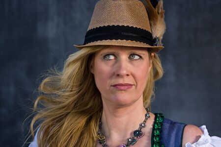 Beautiful Bavarian Woman with long blond hair in traditional clothing - ready for Oktoberfest,...