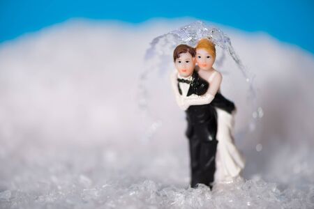 Groom carrying his bride through the snow.の写真素材