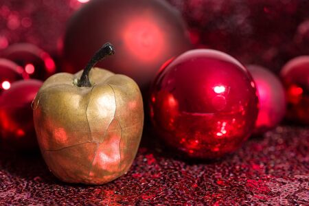 Golden apple and red Christmas baubles.の写真素材