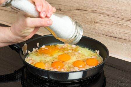 Ready for breakfast: cooking scrambled eggs in a modern kitchen.の写真素材