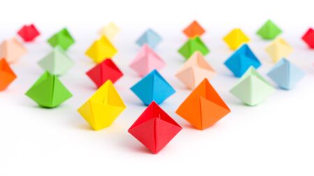 Fleet of origami paper ships in triangle shape isolated on white - like a overwhelming flood