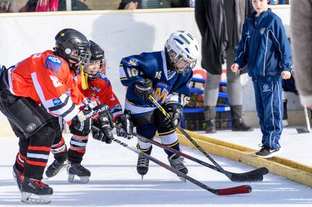 Fuerstenfeldbruck, Bavaria, Germany - 06. February 2016: German Kids playing ice hockey. Age is about 10 years. Players are fighting for the puck.のeditorial素材