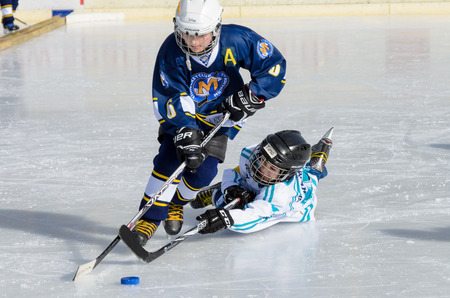 Fuerstenfeldbruck, Bavaria, Germany - 06. February 2016: German Kids playing ice hockey. Age is about 10 years. Desperate last minute defense, but blue player goes through.のeditorial素材