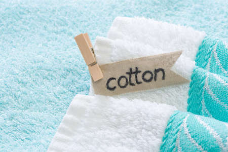 Stack of bath towels with cotton lettering, showing use of natural materialsの写真素材