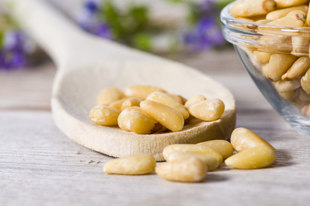 Group of pine nuts with spoon in cooking environment.の写真素材
