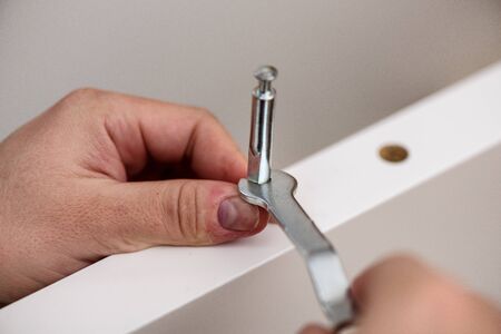 Handyman DIY construction at home: close up on hands with wrench assembling furniture.の写真素材