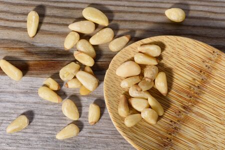 Group of pine nuts with spoon in cooking environment.の写真素材