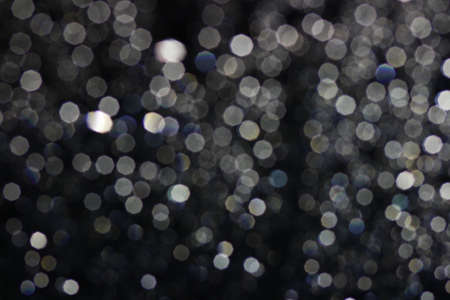 Glare was taken to a polygon bokeh. A black background with white reflective paint.の写真素材