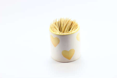 A toothpick inserted in the cup brought by a white heart. On a white backgroundの写真素材