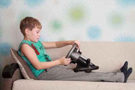 child on couch with computer-game deviceの写真素材