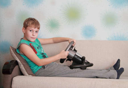 child on couch with computer-game deviceの写真素材