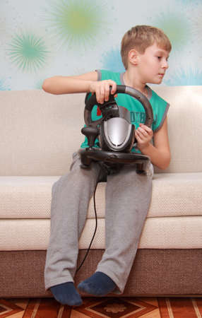 child on couch with computer-game deviceの写真素材